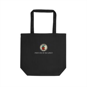 Da Moa 'First One in the Lineup' badge on a black eco canvas tote bag