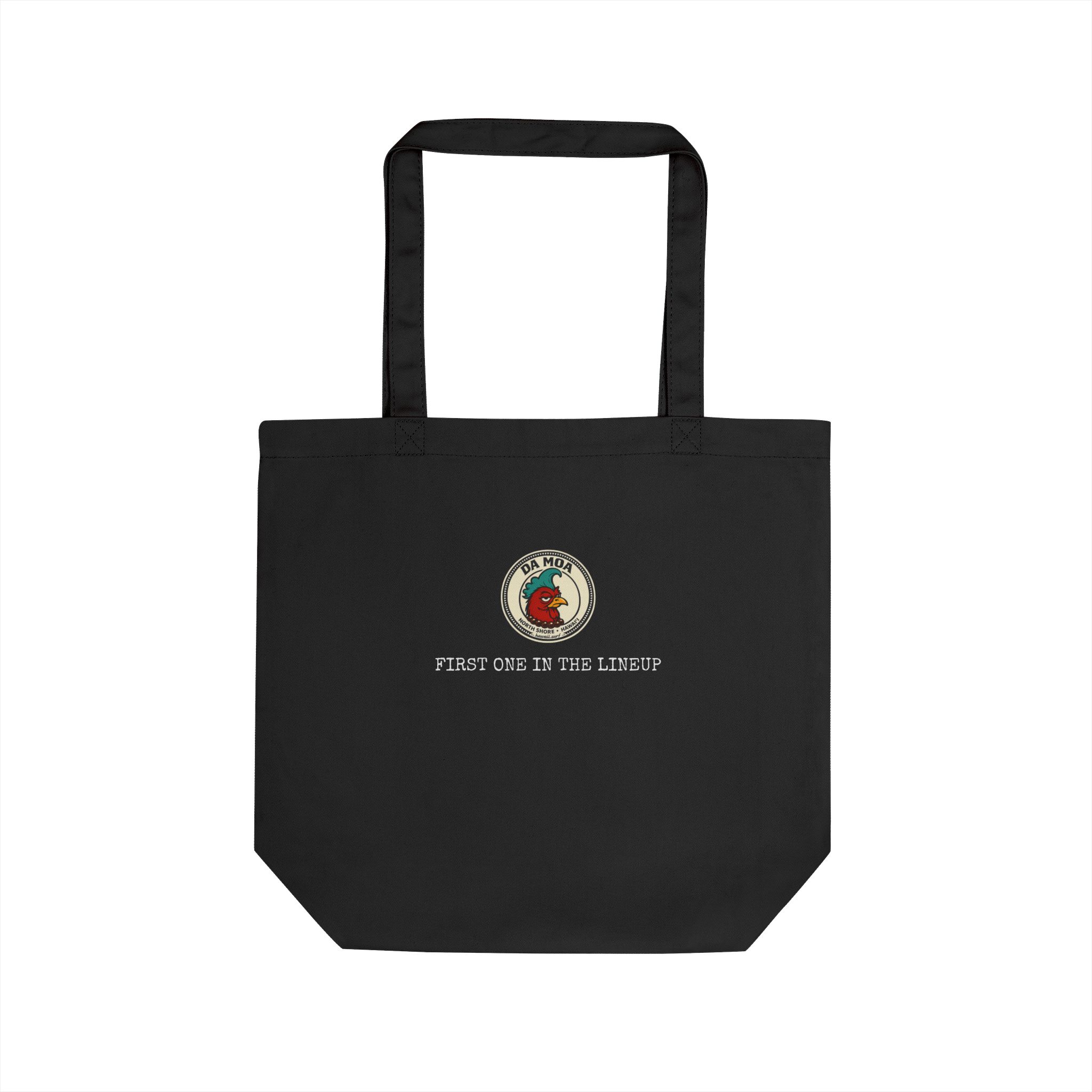Da Moa 'First One in the Lineup' badge on a black eco canvas tote bag
